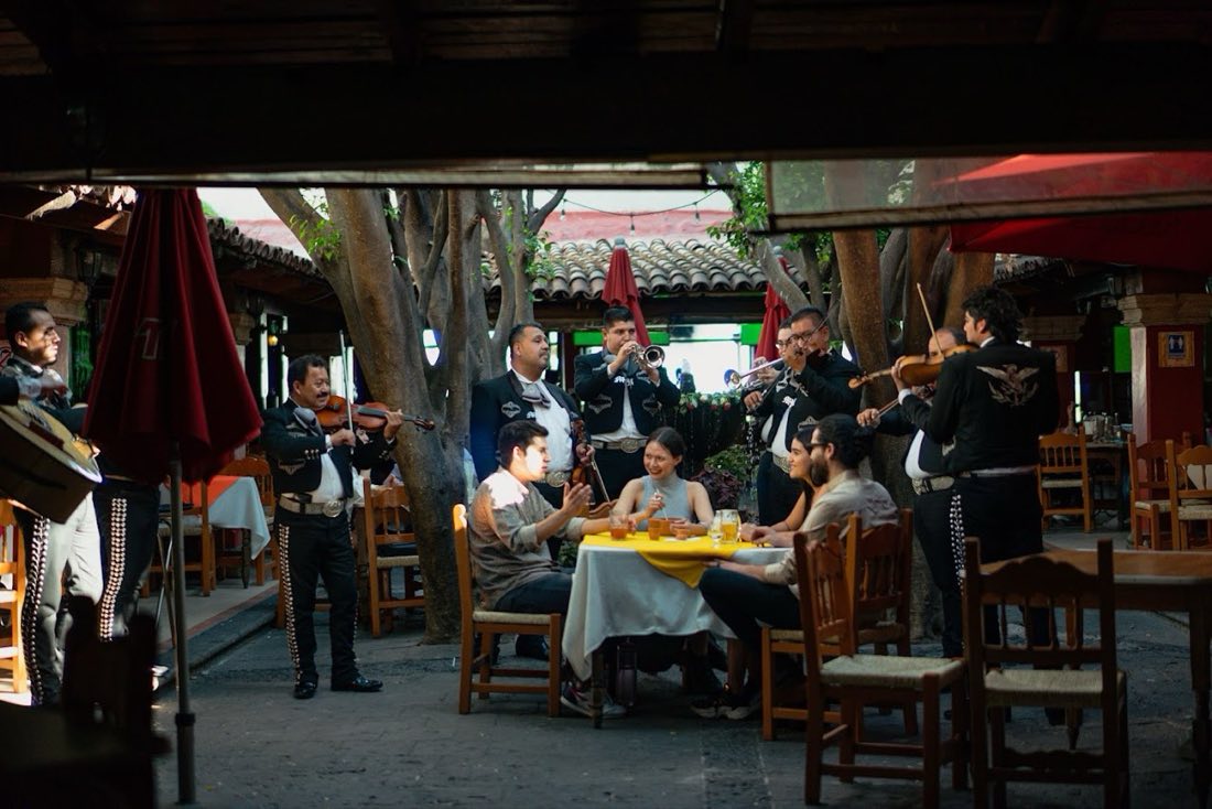 Mariachis tocan violín y trompeta junto a una pareja