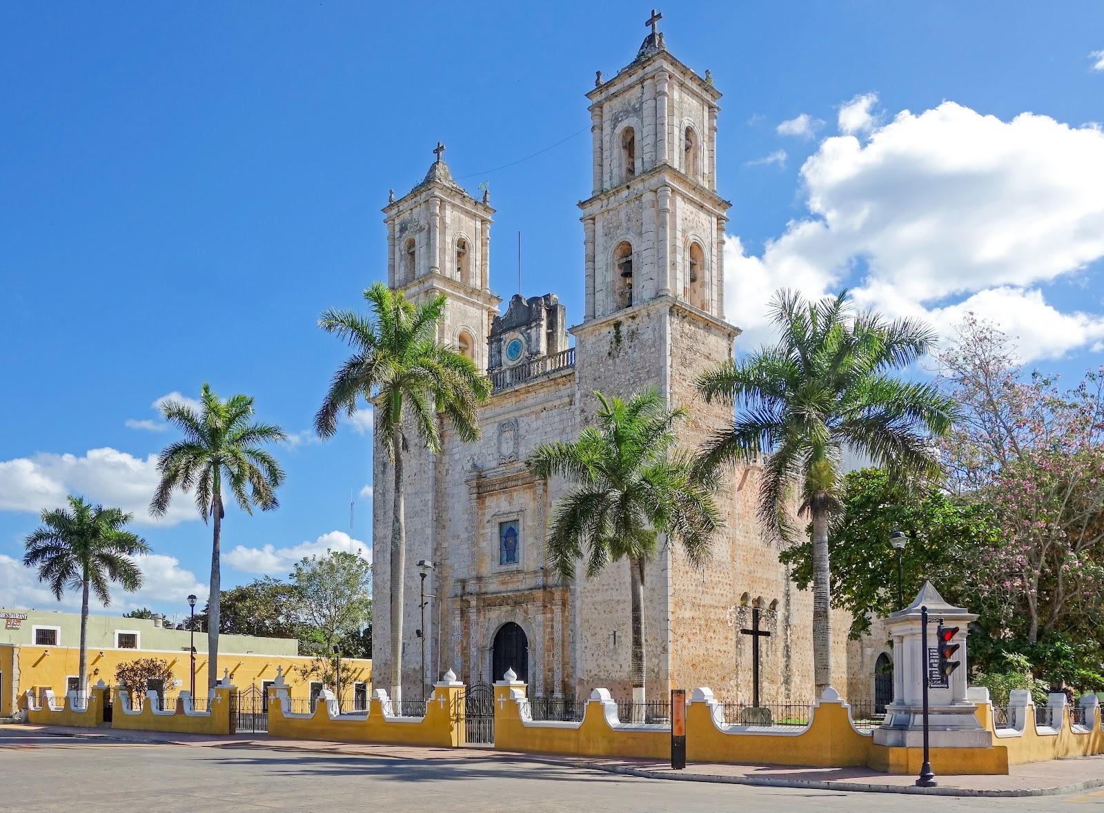 La catedral colonial de San Servacio en Valladolid bajo un cielo azul intenso, enmarcada por altas palmeras