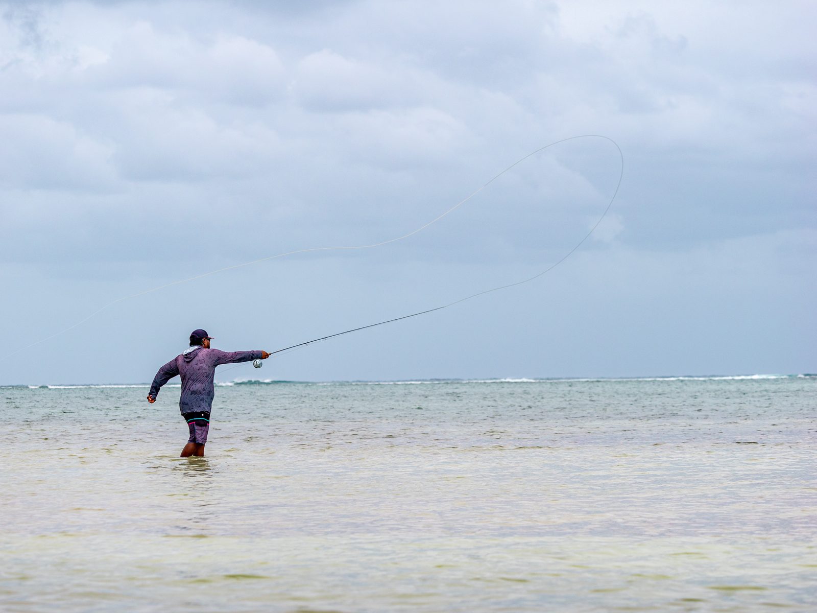 Un pescador lanzando la línea de mosca sobre los flats