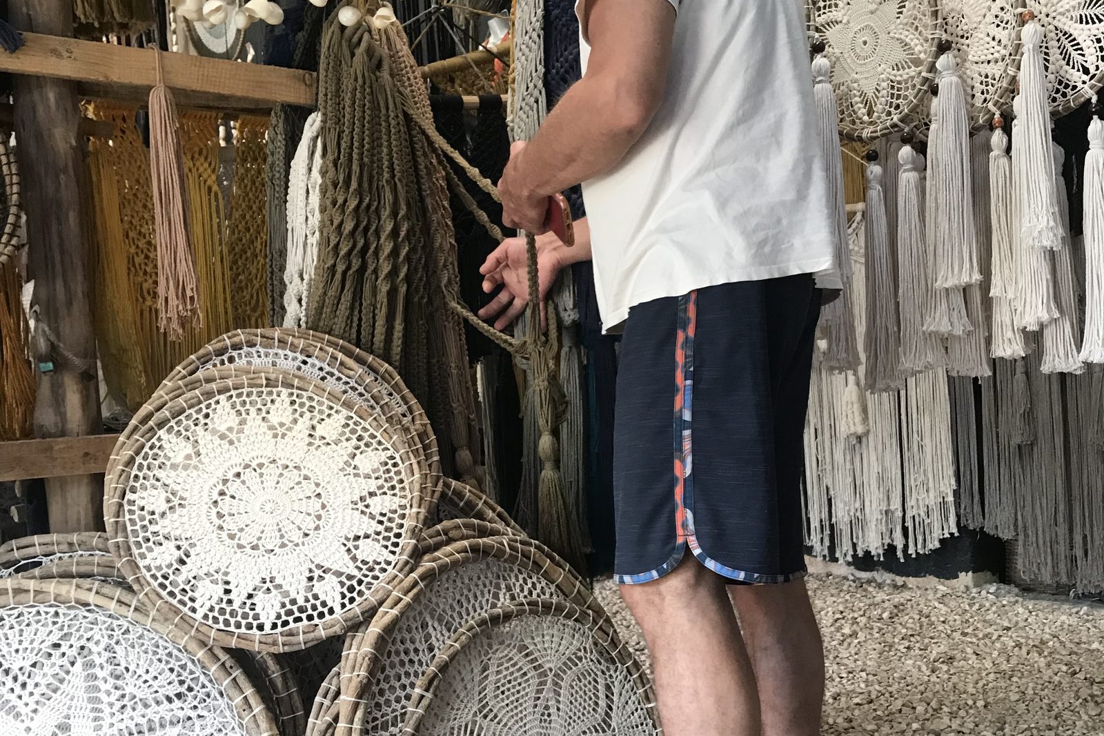 Mandalas tejidos redondos apilados en el piso de una tienda artesanal