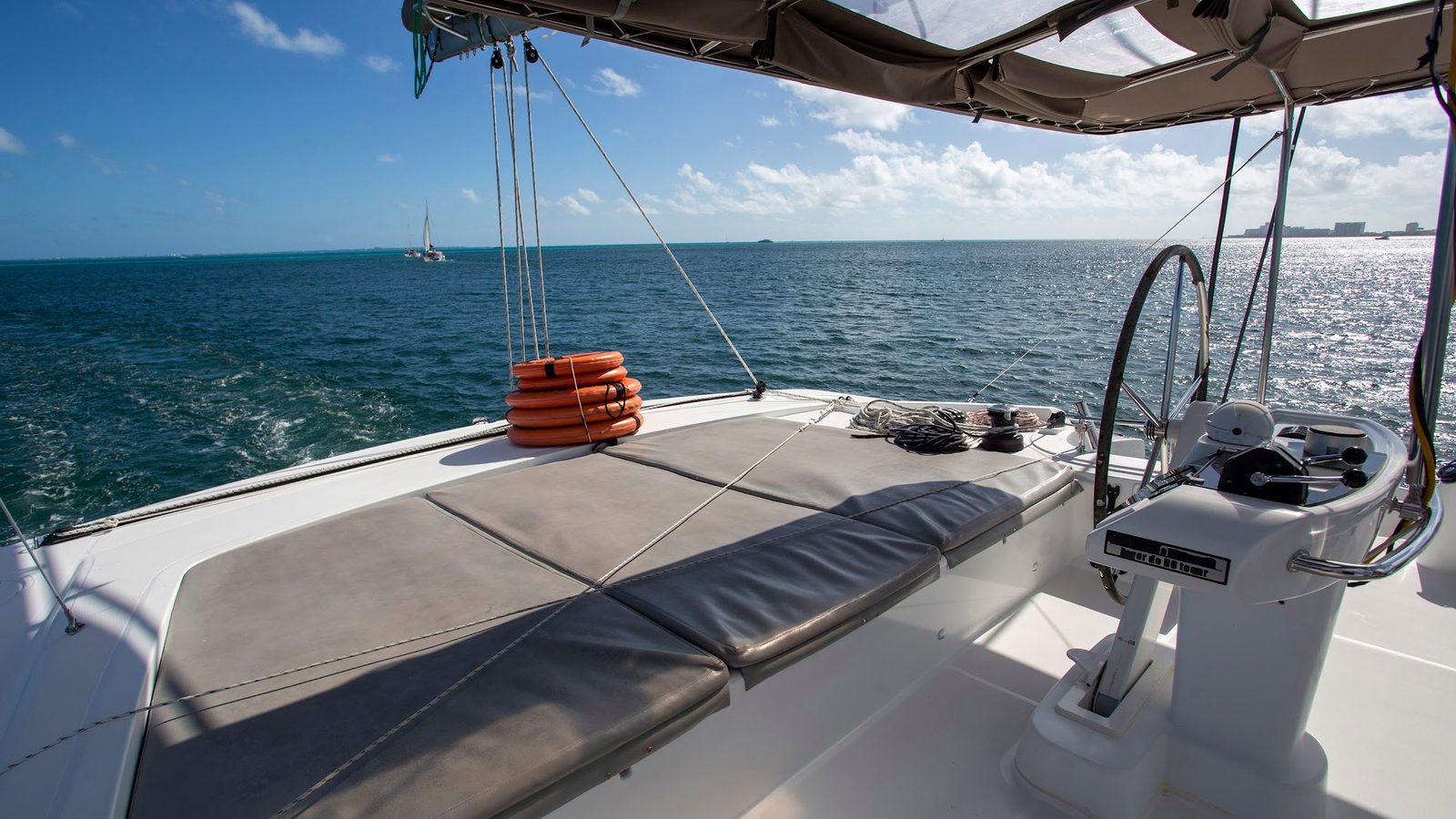 The upper deck sun pad with the helm and the open sea