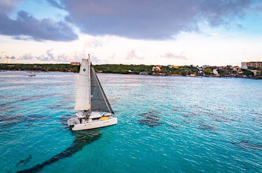 Carpe Diem sailing over turquoise water near the coast