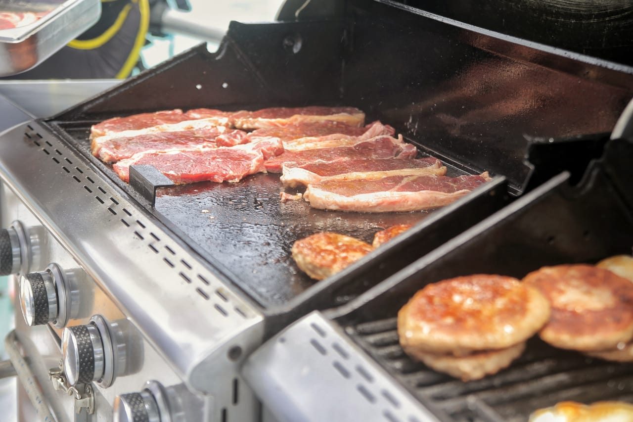 Steak and burgers on the grill on board