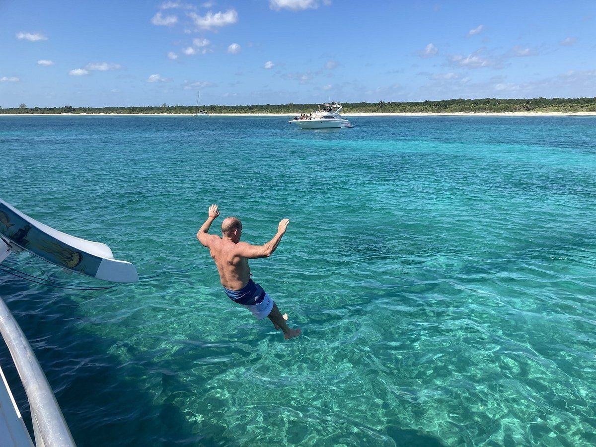 A guest jumping into the turquoise water beside the slide