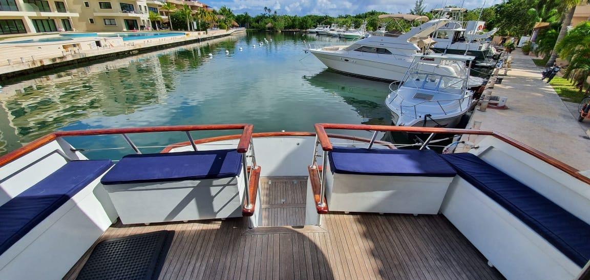 Sun beds and teak deck on board, with the marina behind