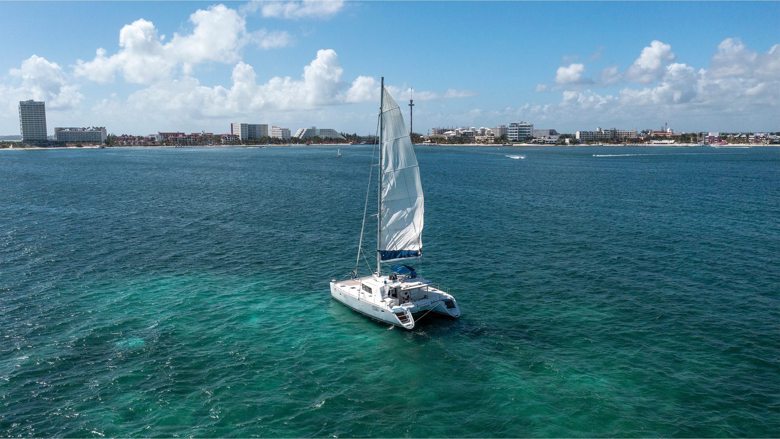 Quidam under sail with Cancún’s Hotel Zone behind