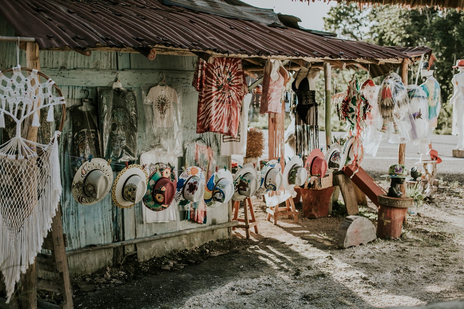 Sombreros pintados a mano, hamacas y atrapasueños afuera de una tienda de artesanías