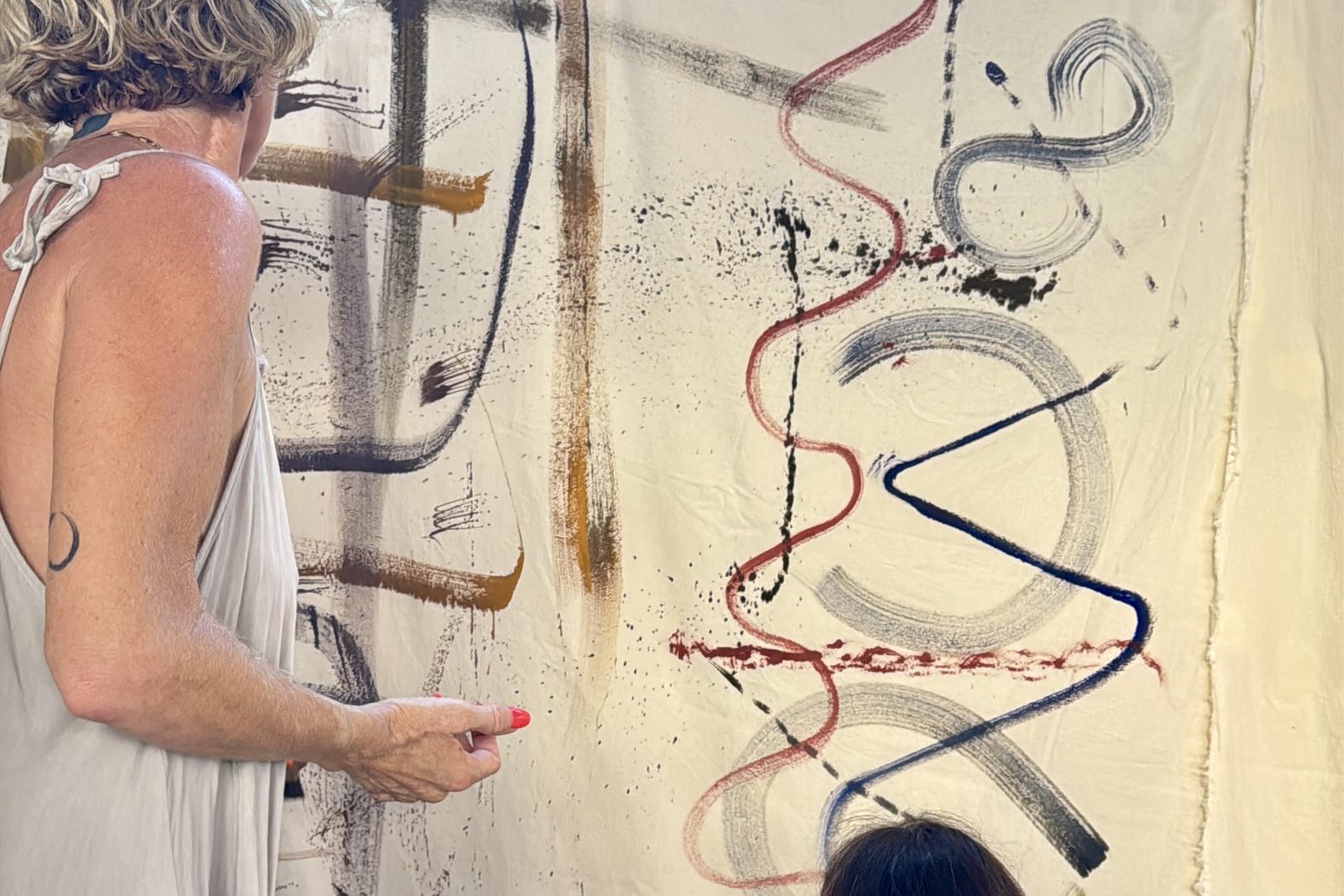 Painting together on a large fabric hung at the villa