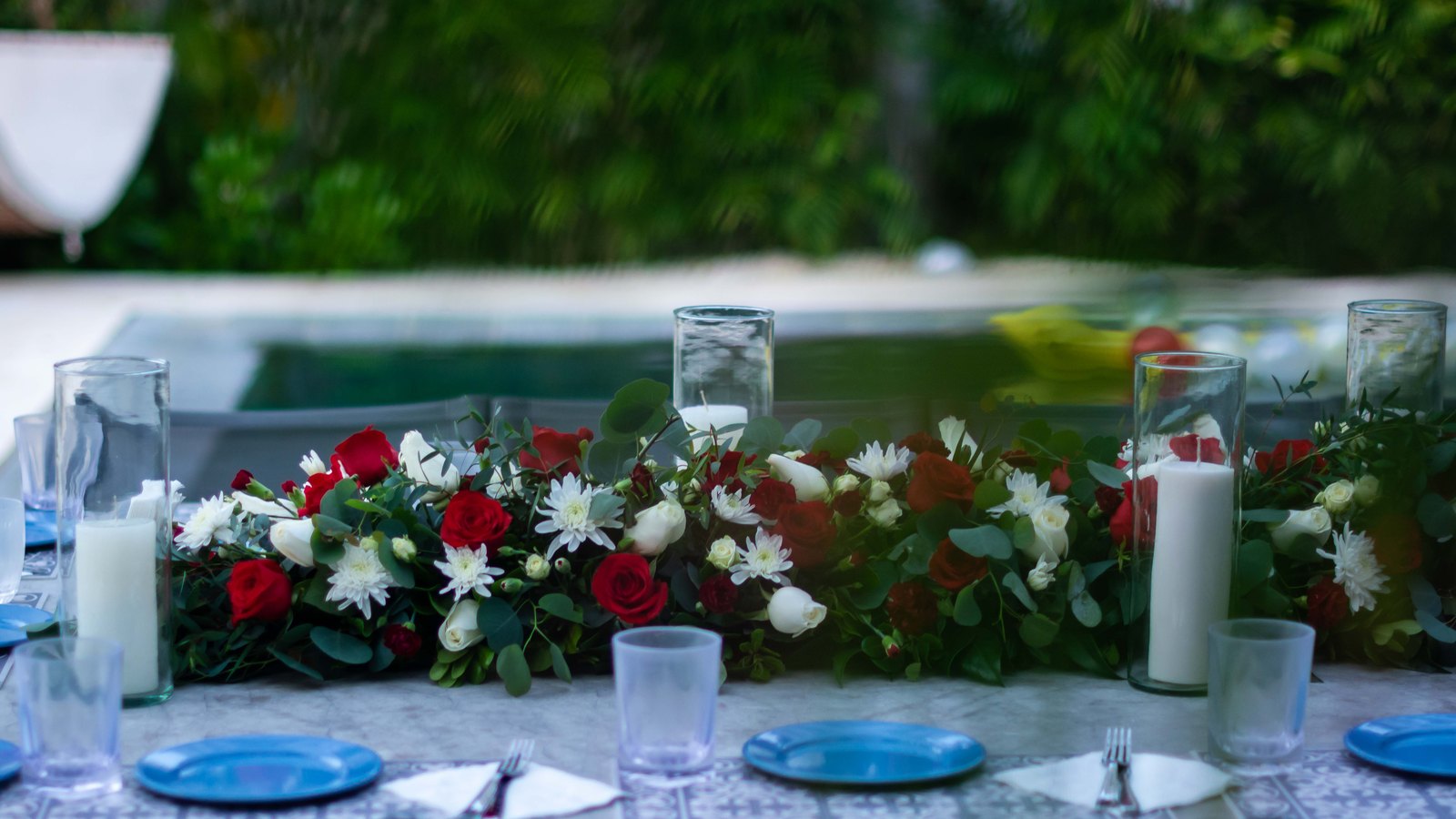 A floral centrepiece of red and white blooms with candles