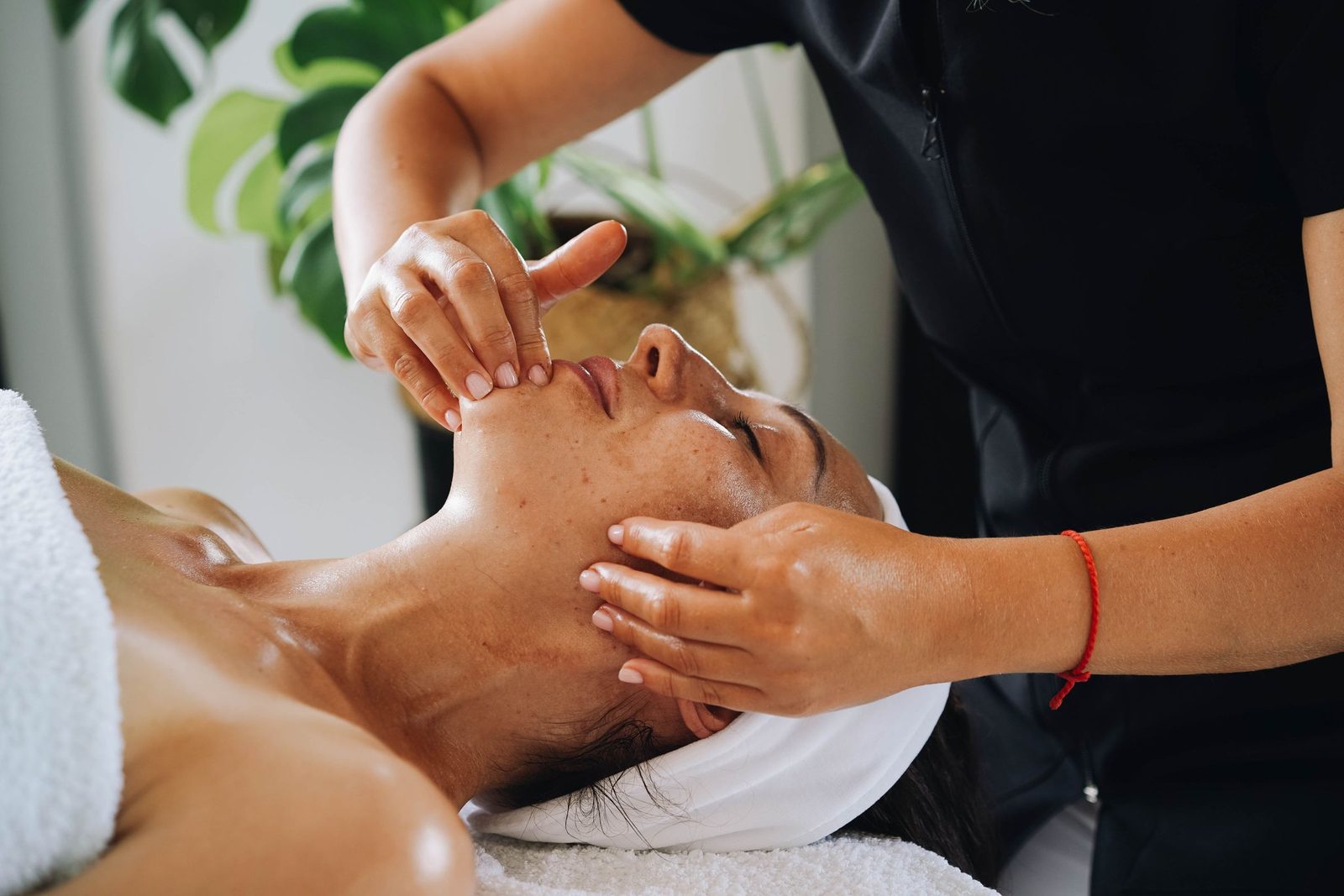 A facial massage with tropical plants in the background