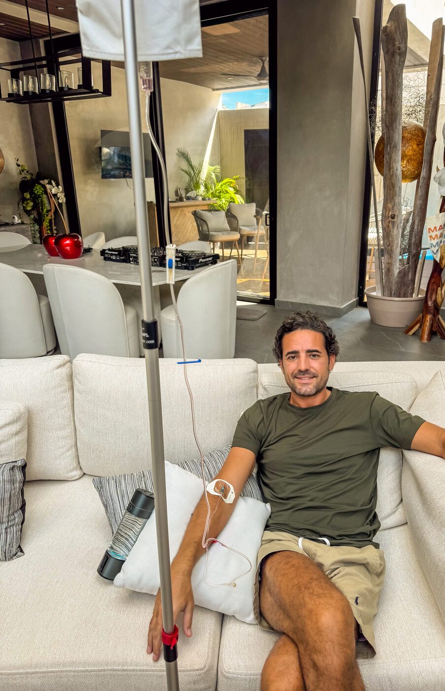 A guest relaxing on a villa sofa during an IV session