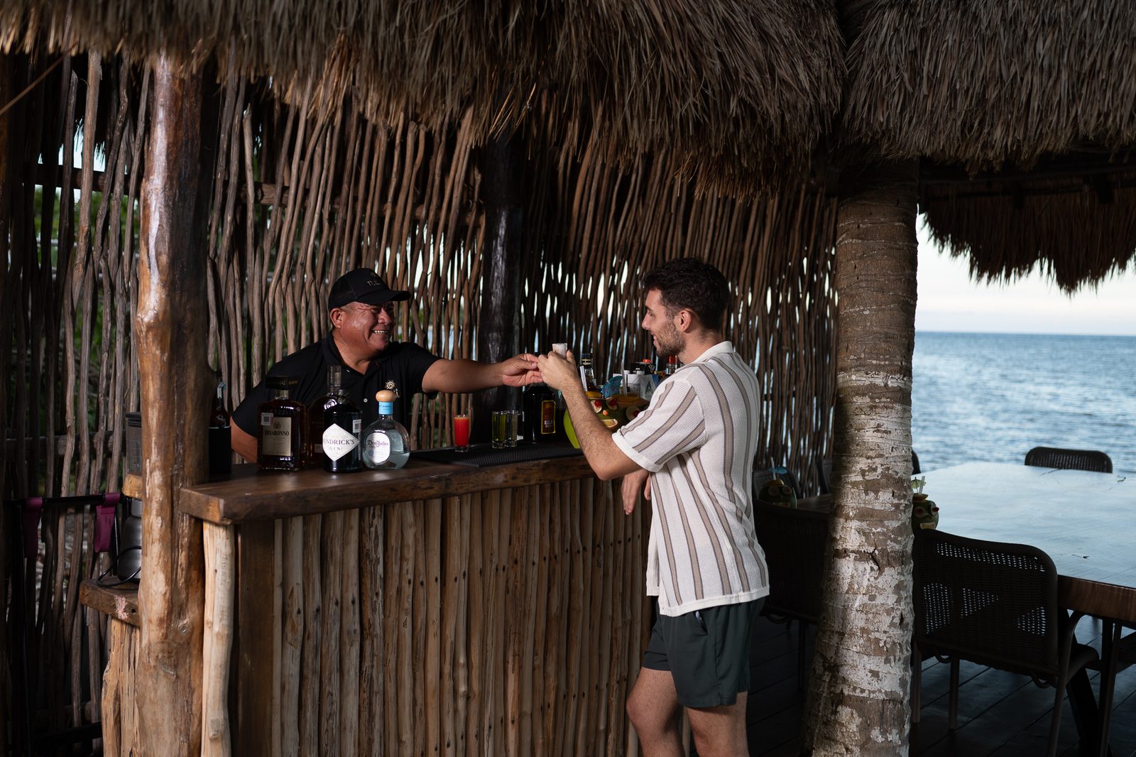 La barra de palapa junto al mar al atardecer
