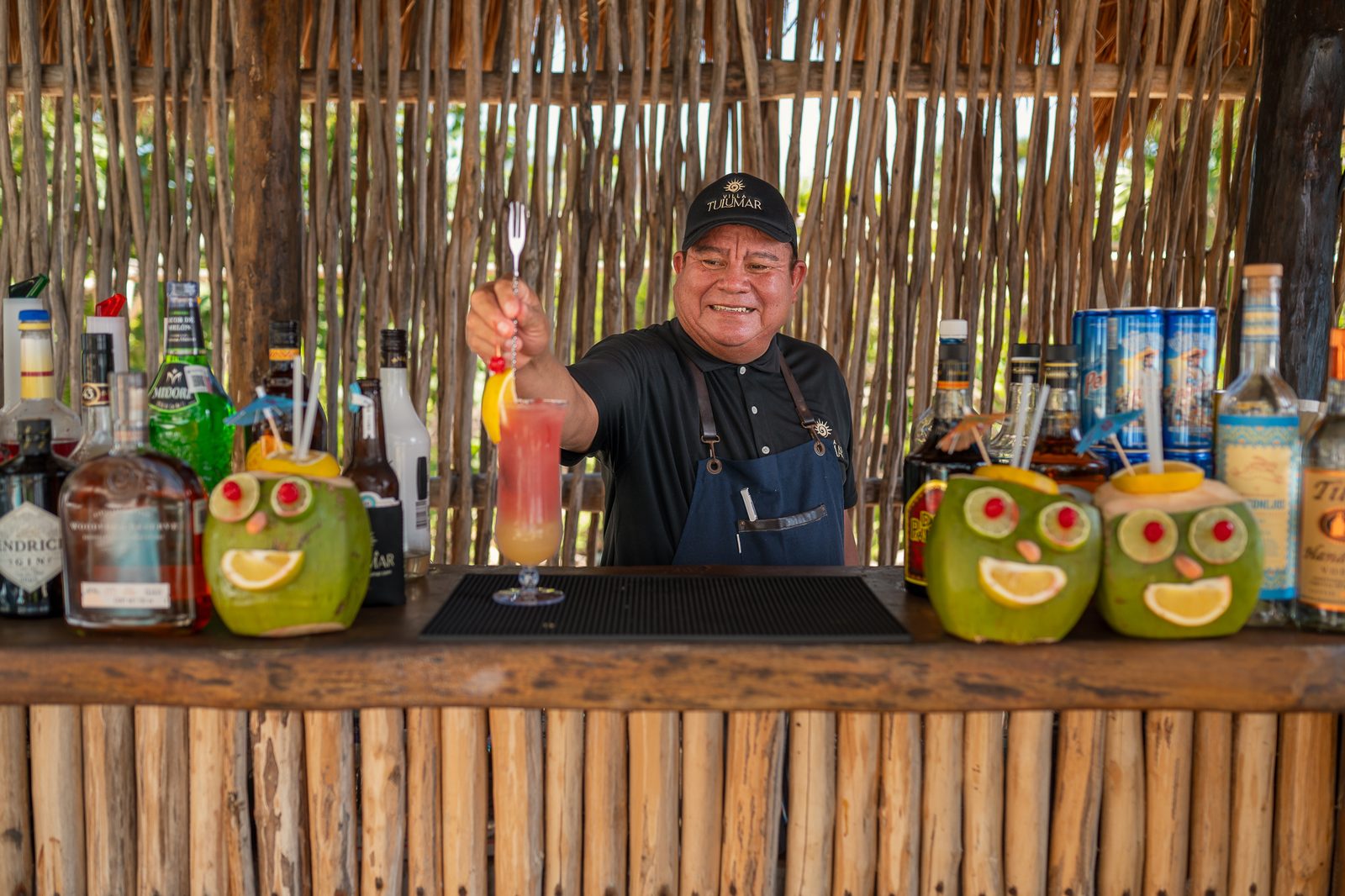 The bartender finishing a cocktail behind the bar