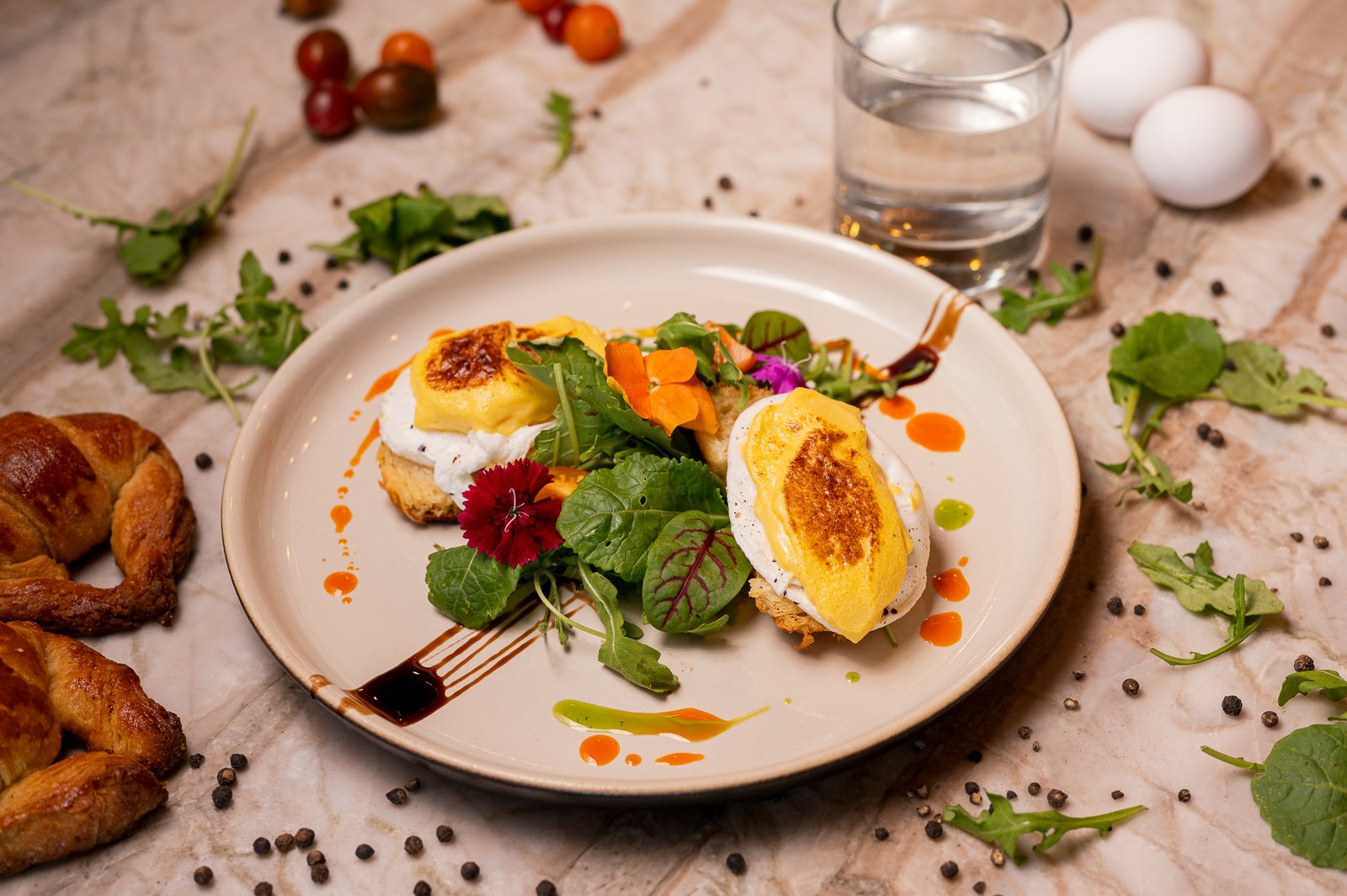 A breakfast plate with eggs, greens and edible flowers