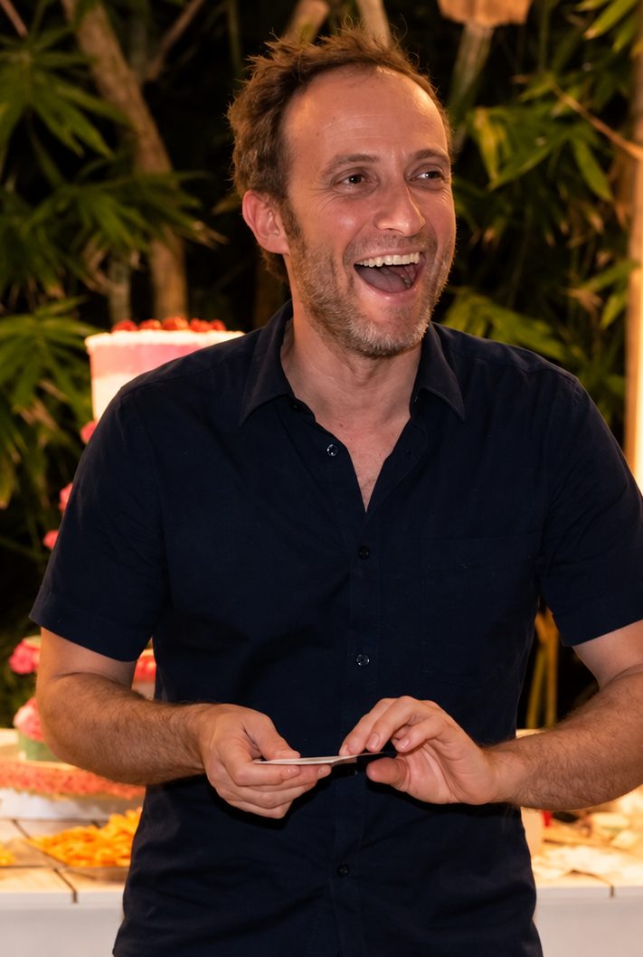 A guest laughing with his chosen card in his hands