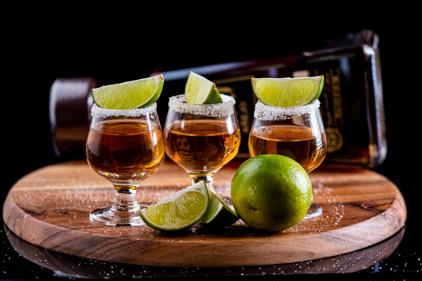 Mezcal servido con limón en una tabla de madera