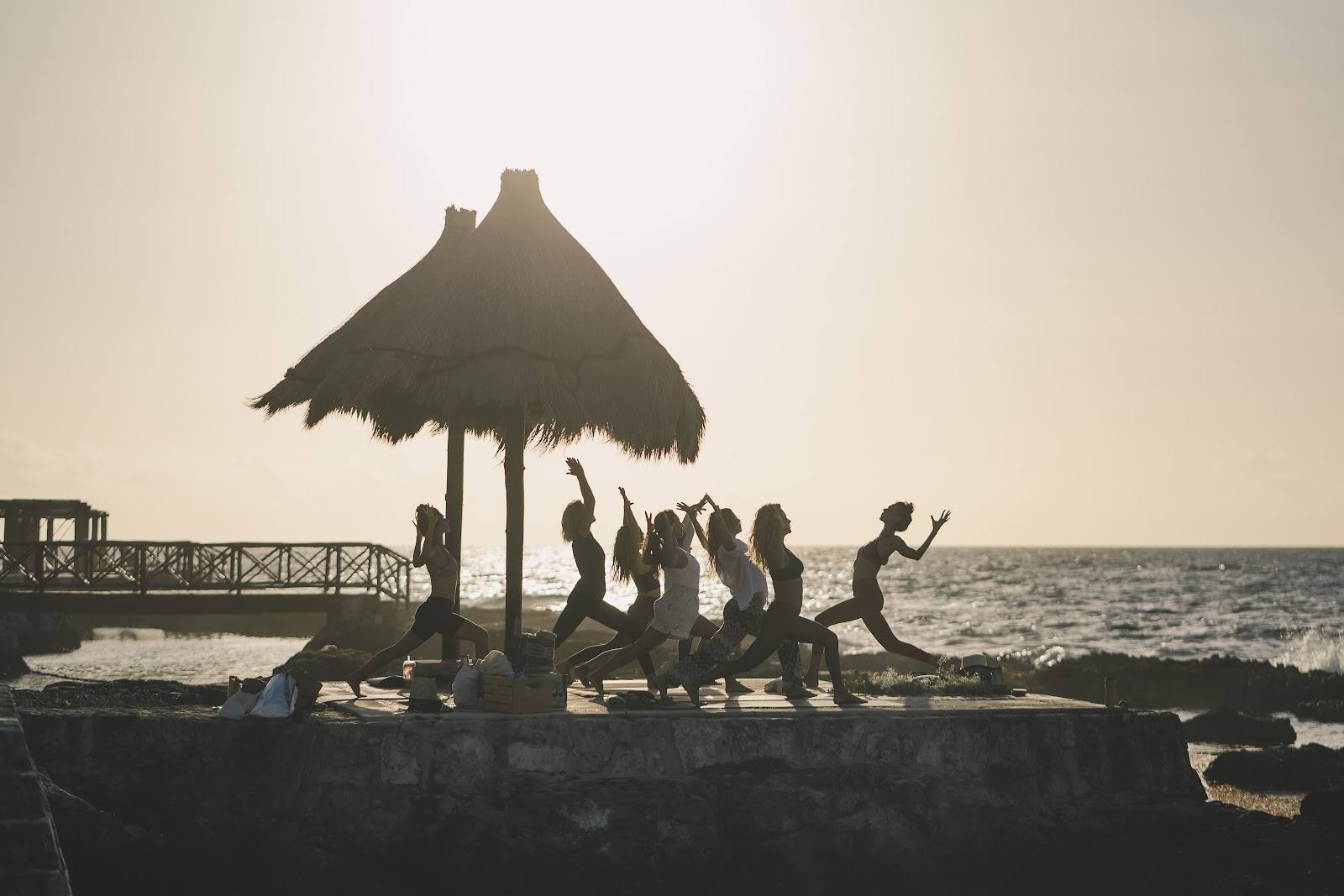 Sunset yoga under a beach palapa