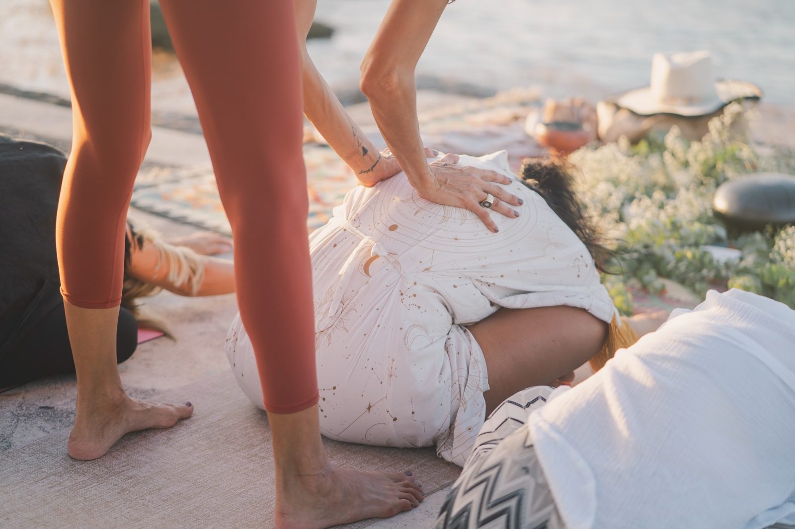 A hands-on adjustment during a restorative pose