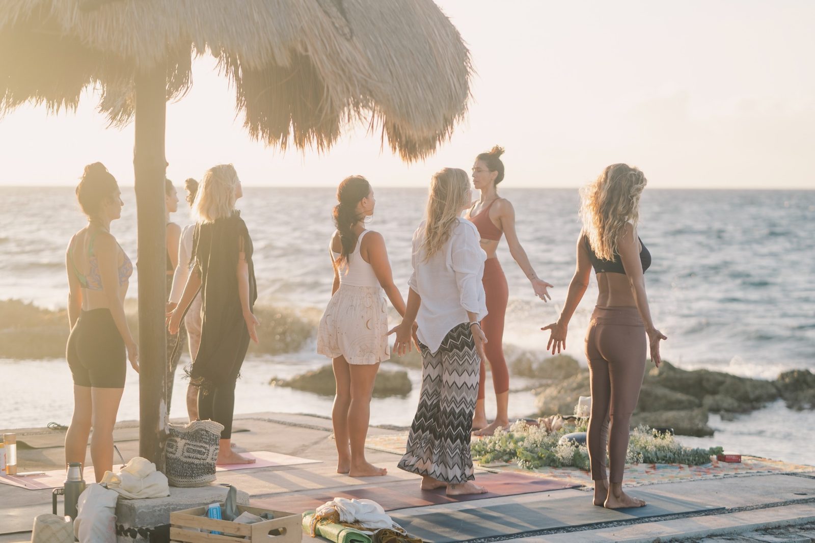 A group standing on their mats facing the sea