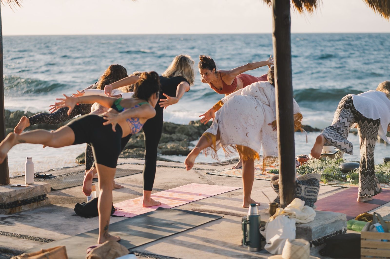 A group holding a balance pose by the sea