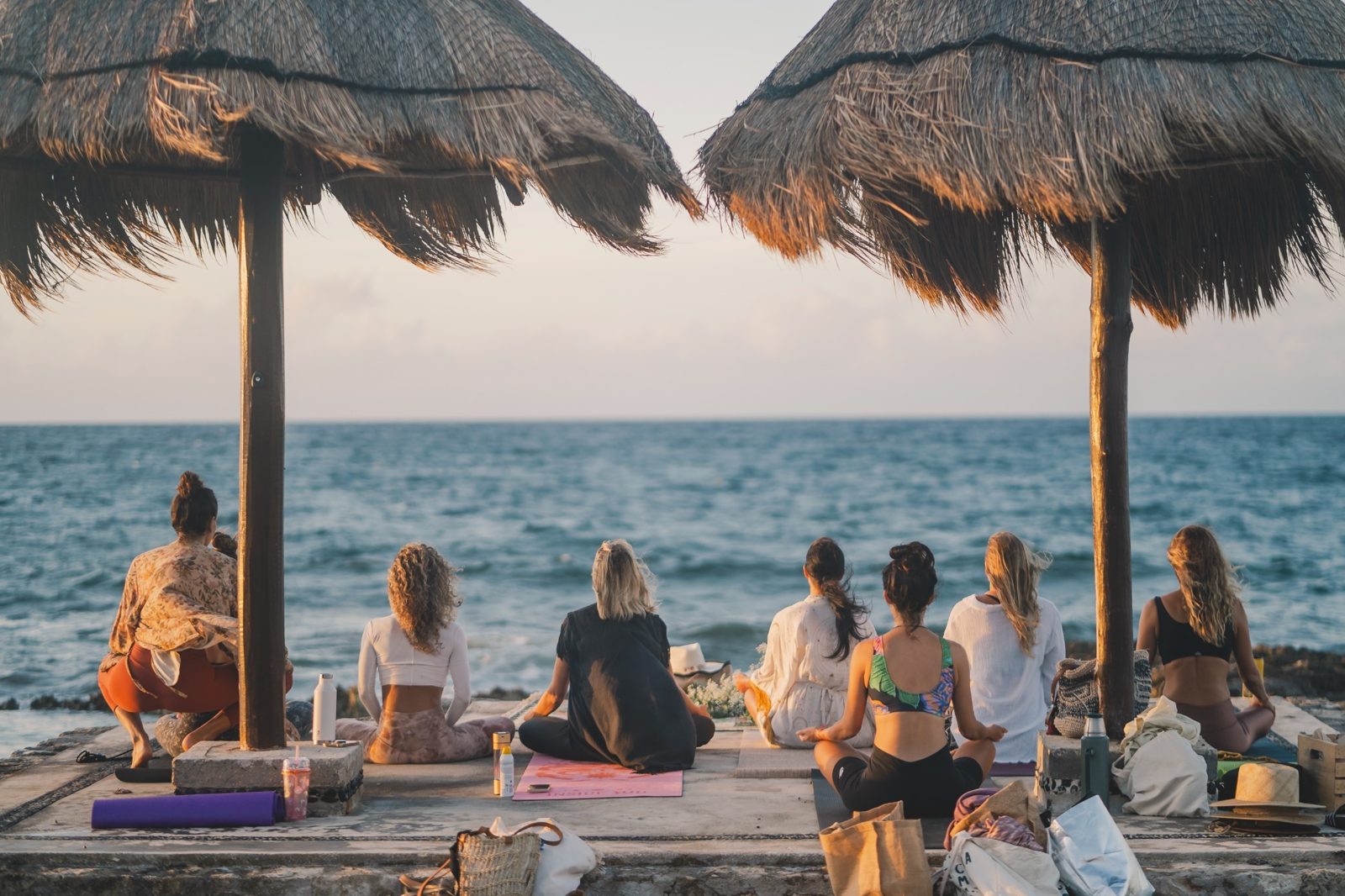 A seated group facing the sea at the end of a practice