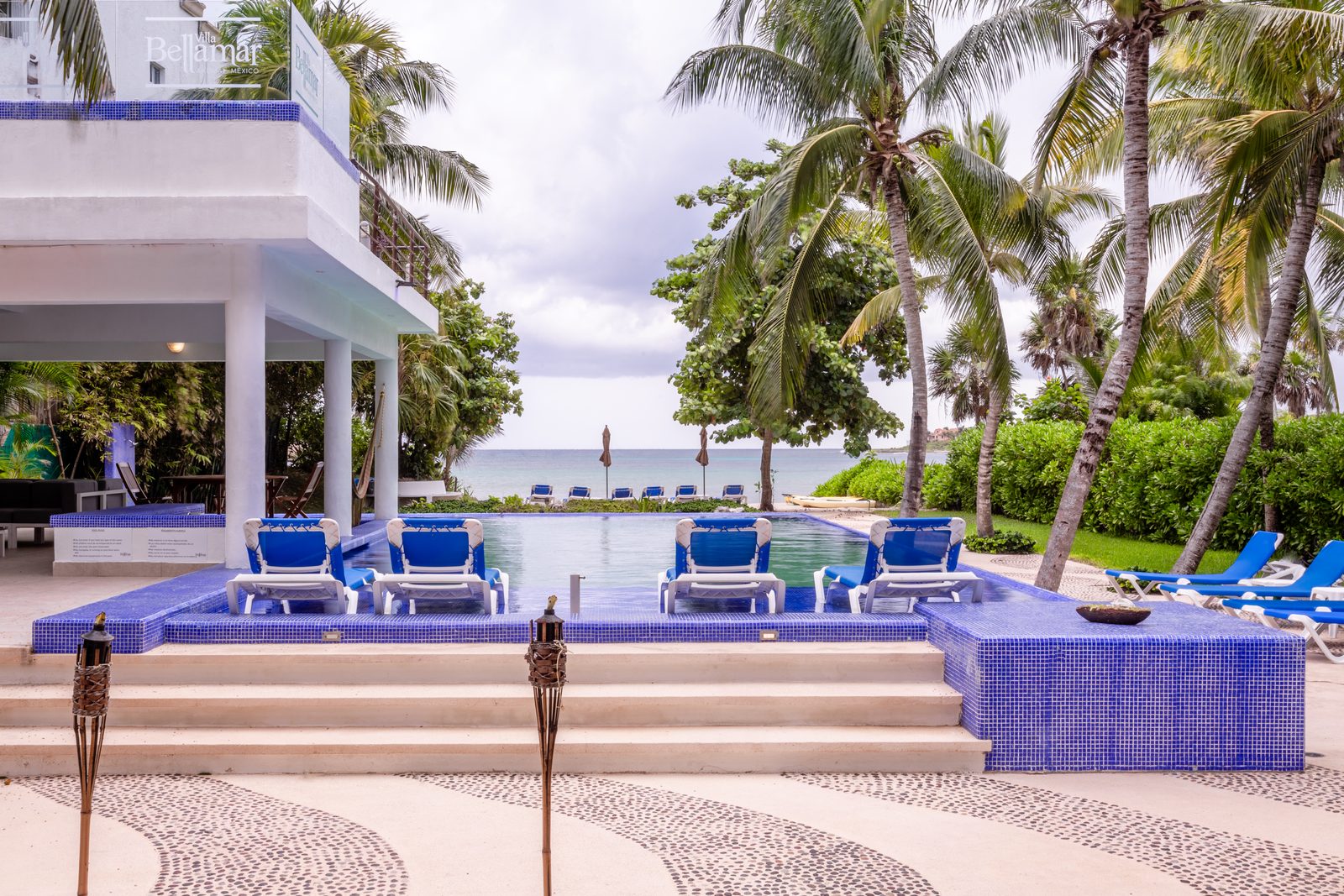 Pool deck of the estate with the Caribbean between the palms