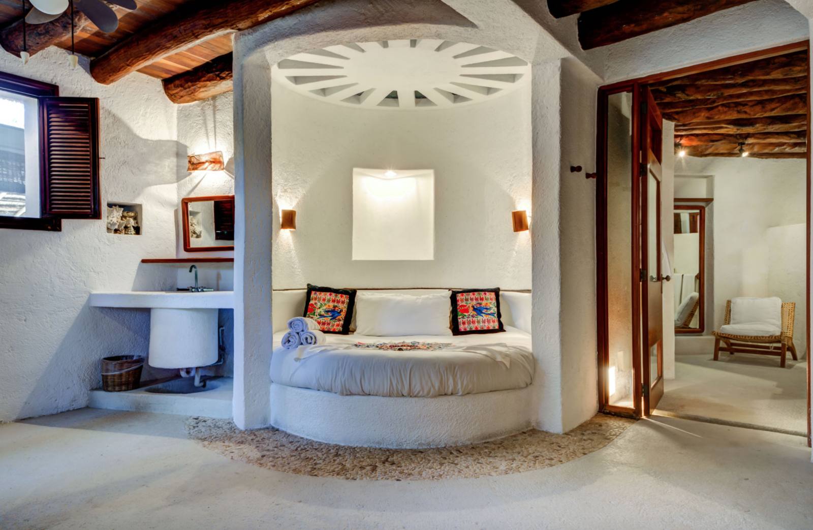 A suite with a round bed and a vanity