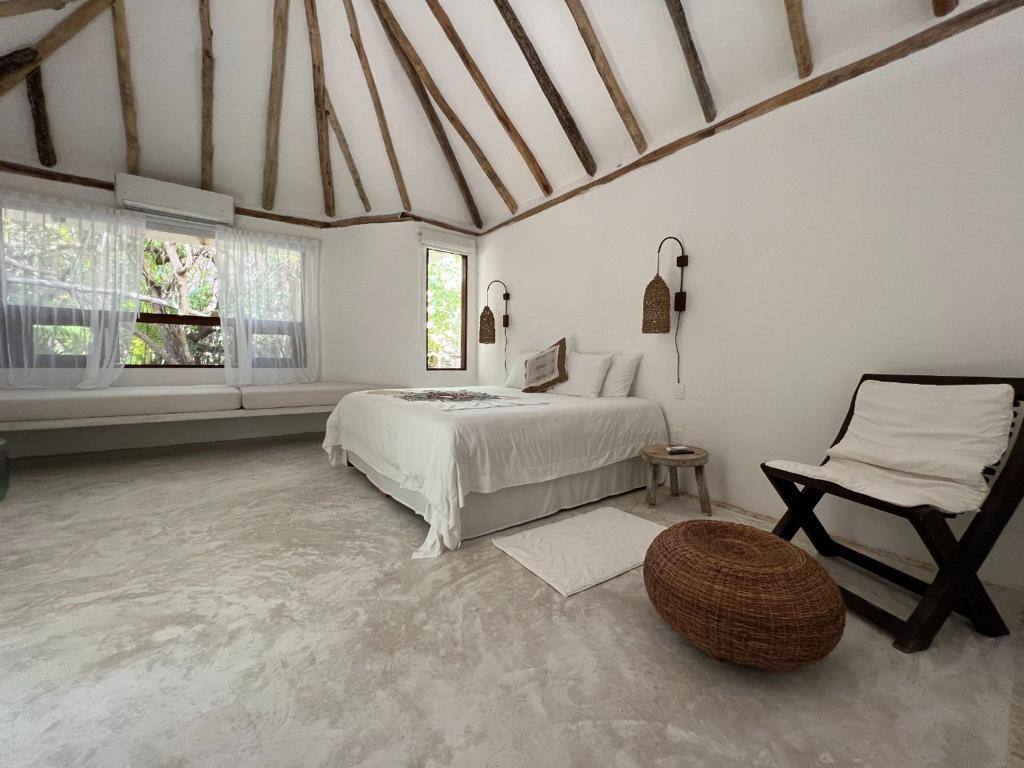 A bedroom under a pitched wooden ceiling