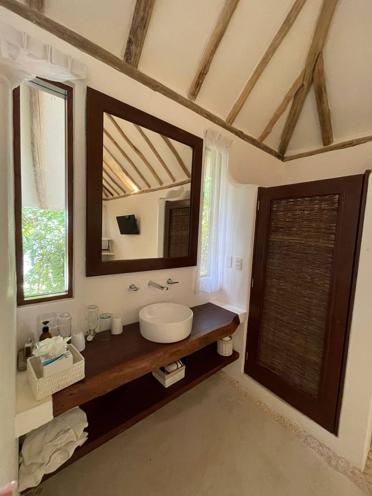 A bathroom with a vessel sink and wooden shutters