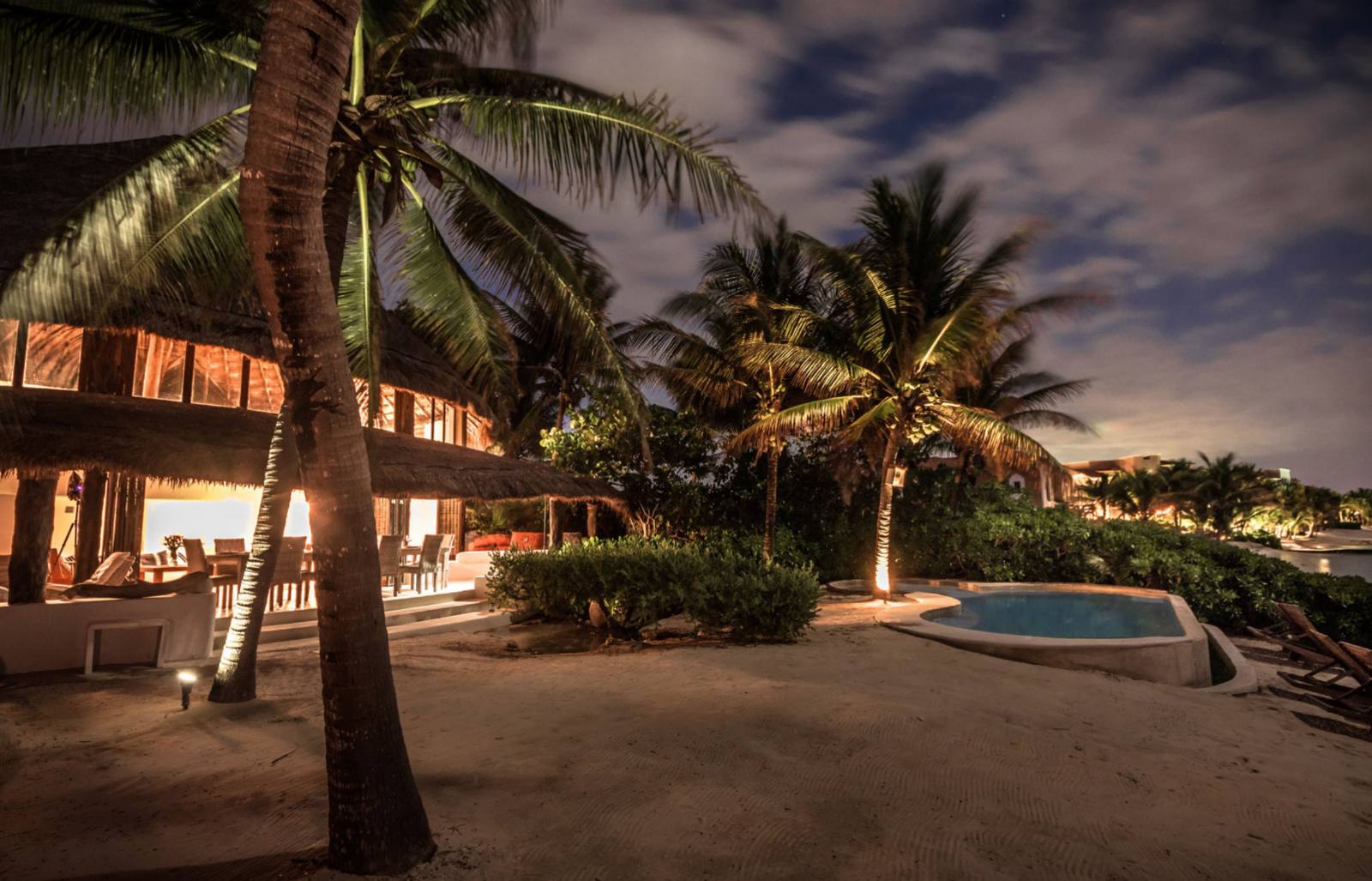 The villa and pool lit up at night