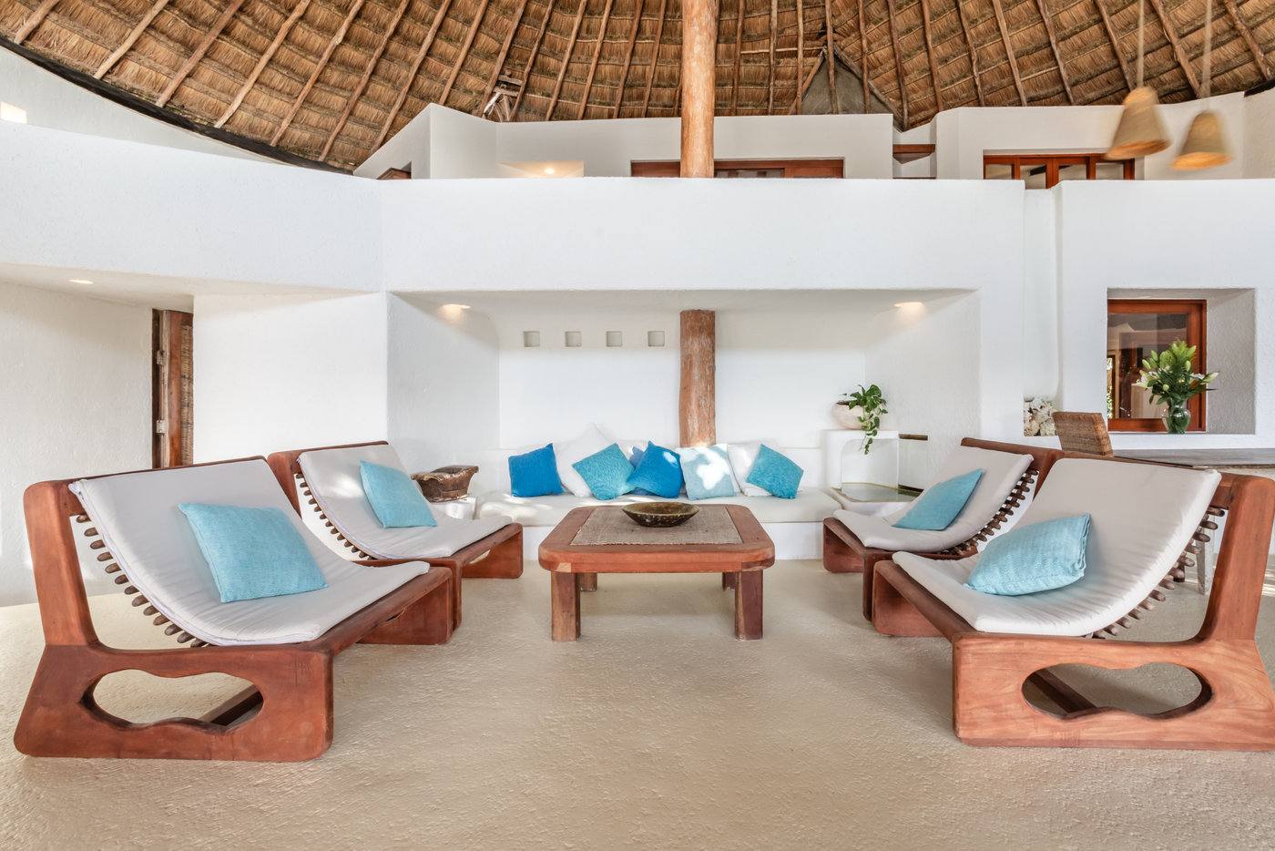 The open-air living room under the thatched roof