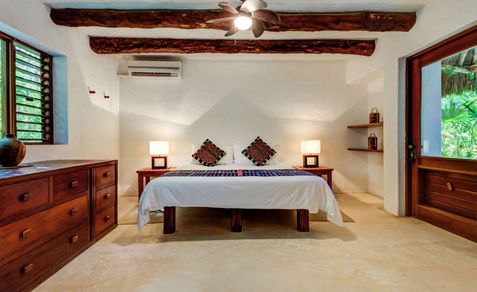 A bedroom with a king bed and a wooden dresser
