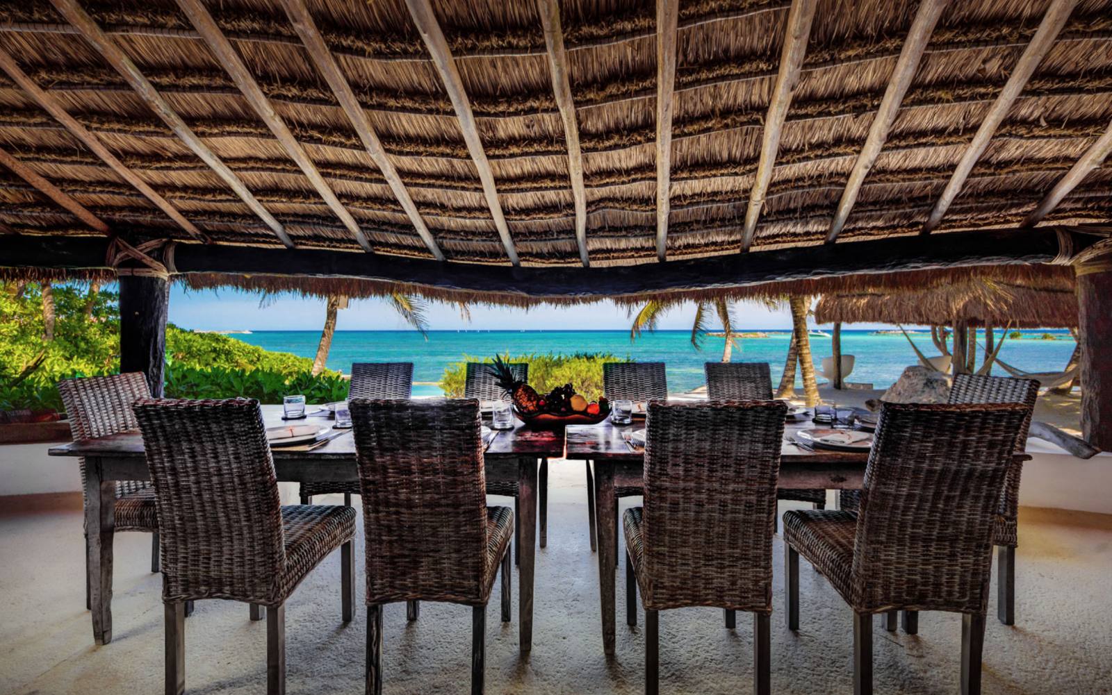 The dining table under the palapa with a view of the sea