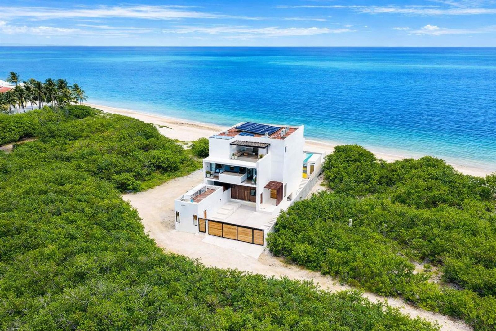 Vista aérea de la villa sobre la playa de Bahía Petempich, entre el mar turquesa y la selva