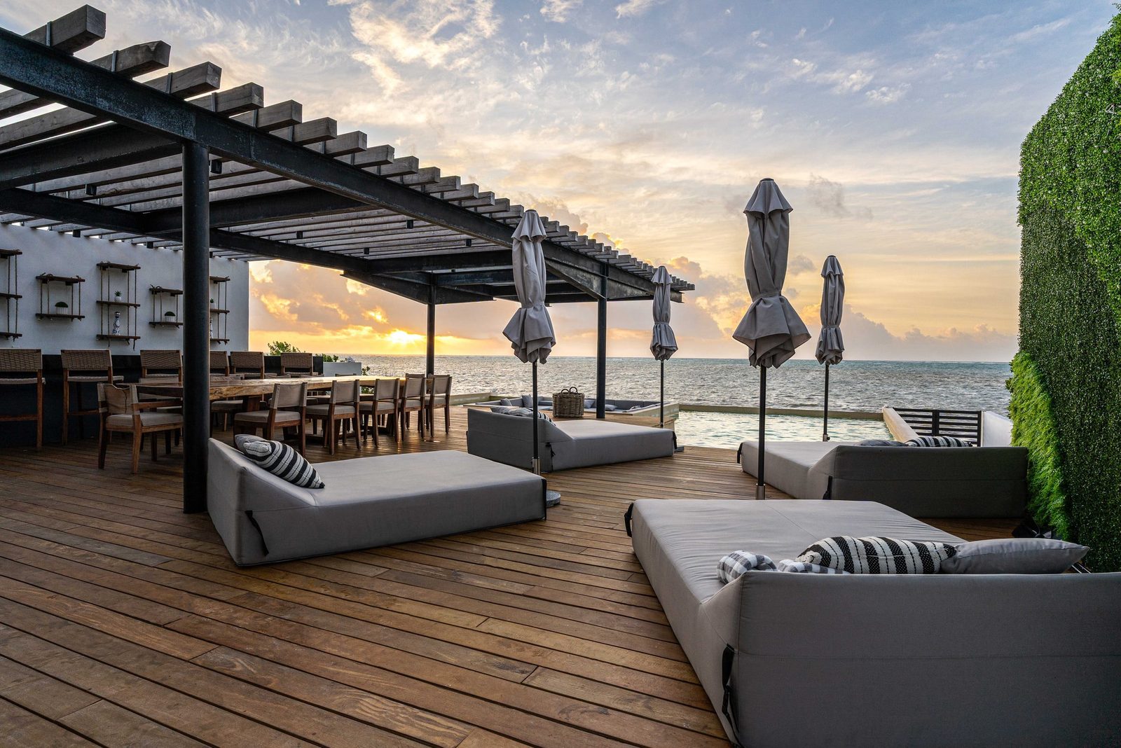 Deck with daybeds and the dining pergola at dusk