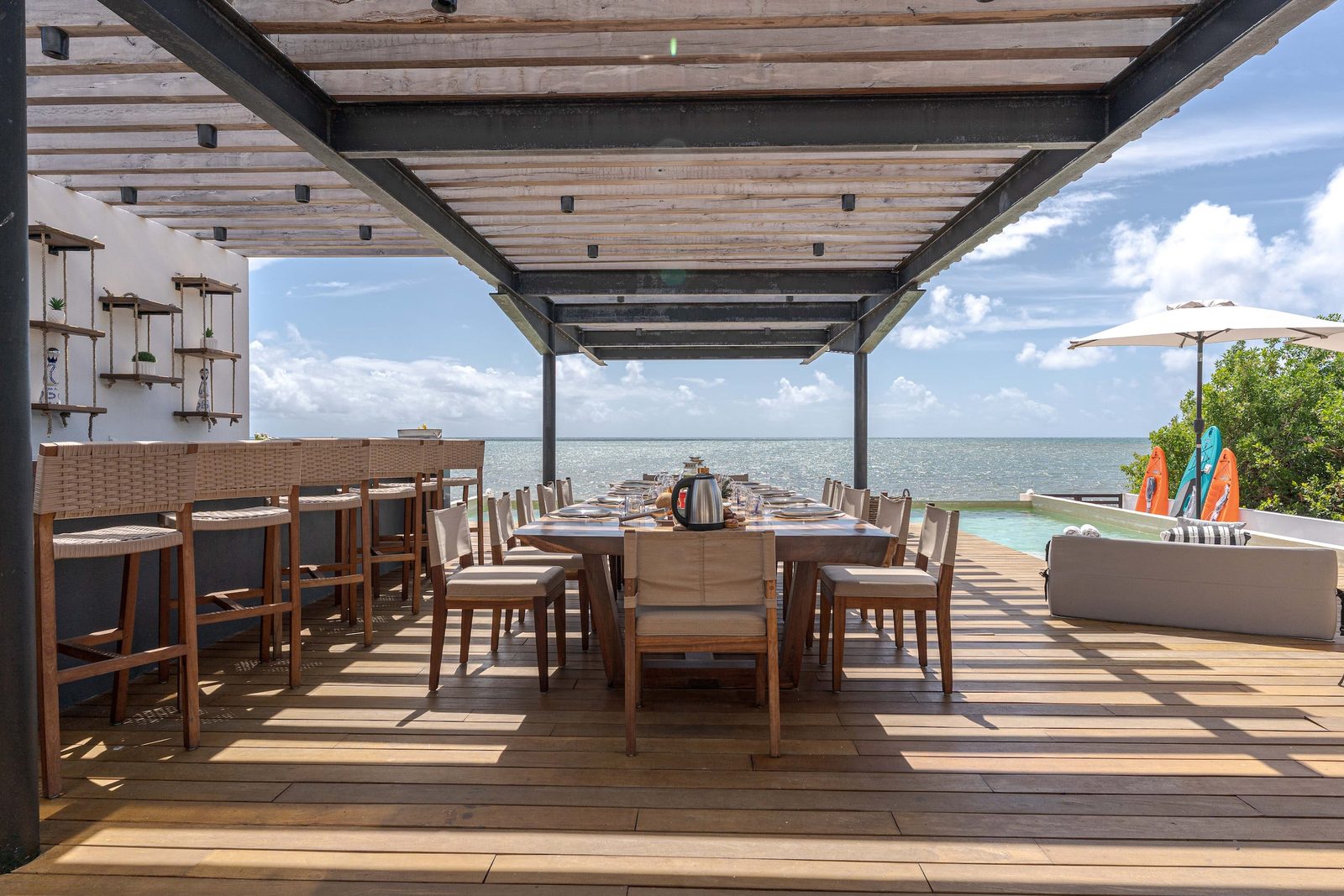 Covered dining terrace with the pool and the sea