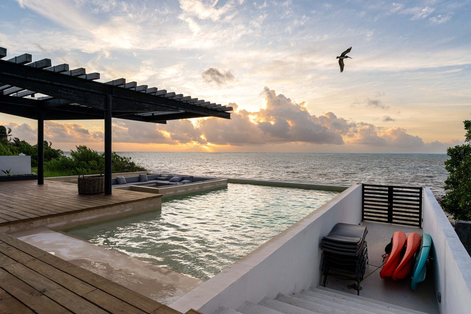The pool and deck facing the sea at sunset