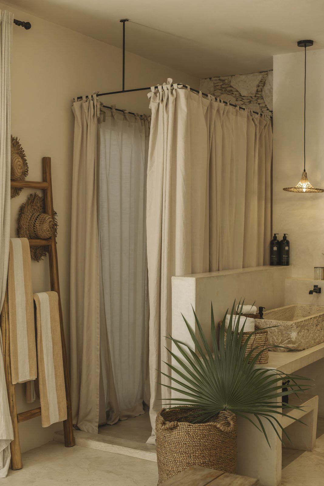 A bathroom with a stone basin and plants
