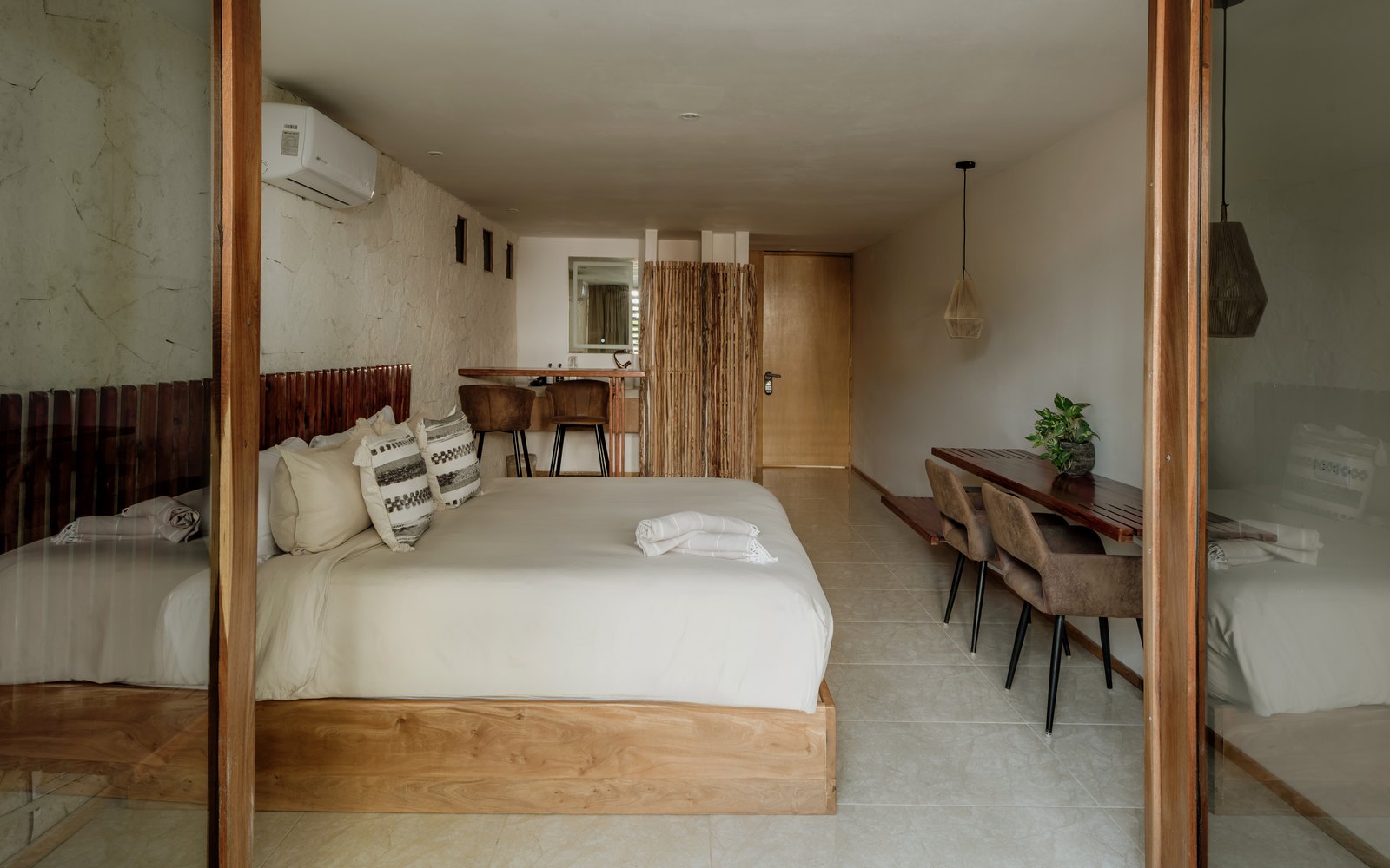 Recámara con muro de piedra y cabecera de madera