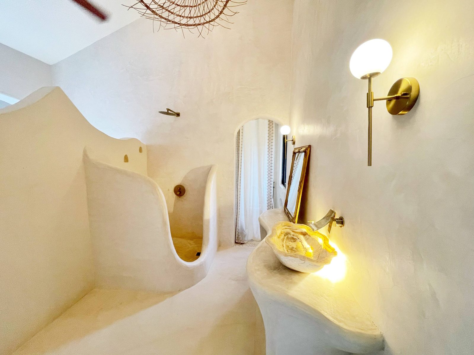 A bathroom with sculpted walls and a round mirror