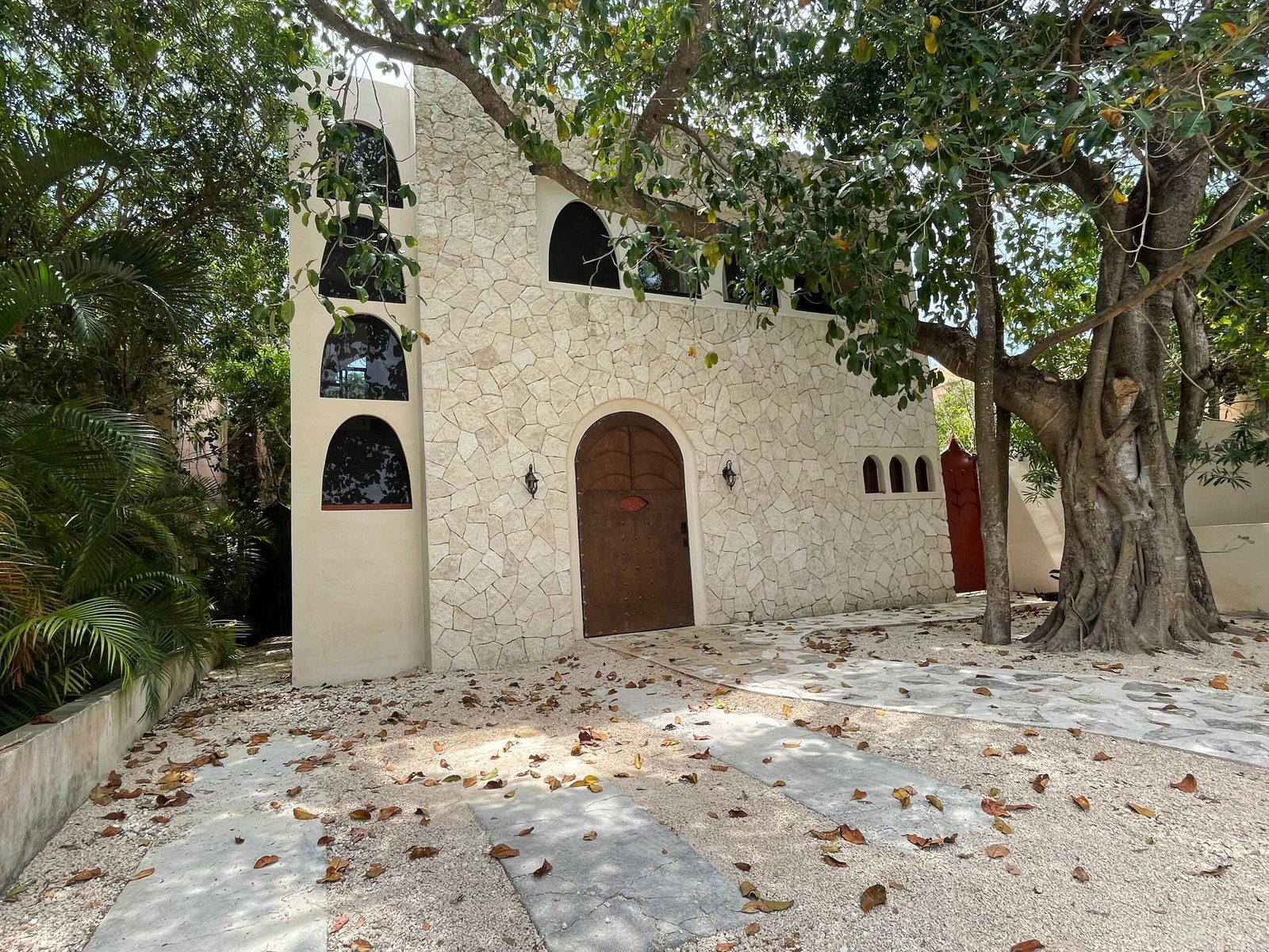 The stone facade under an old tree