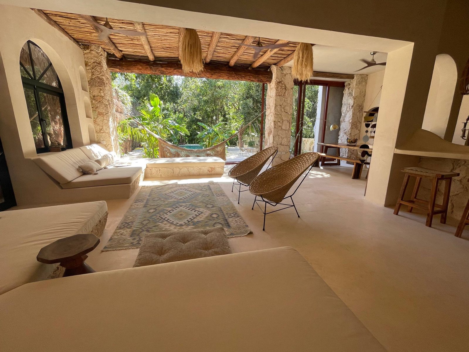 The living room with arched windows and woven chairs