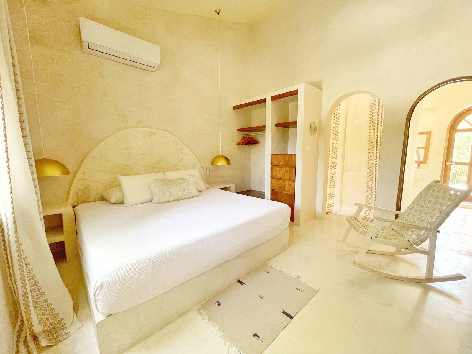 A bright bedroom with an arched doorway