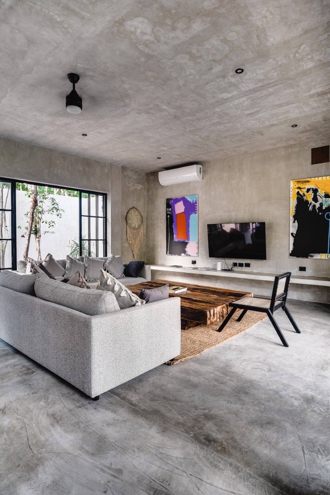 The living room with polished concrete and art on the walls