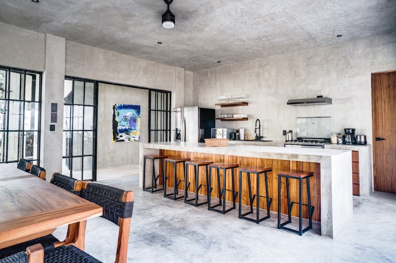 The kitchen with a long bar and stools