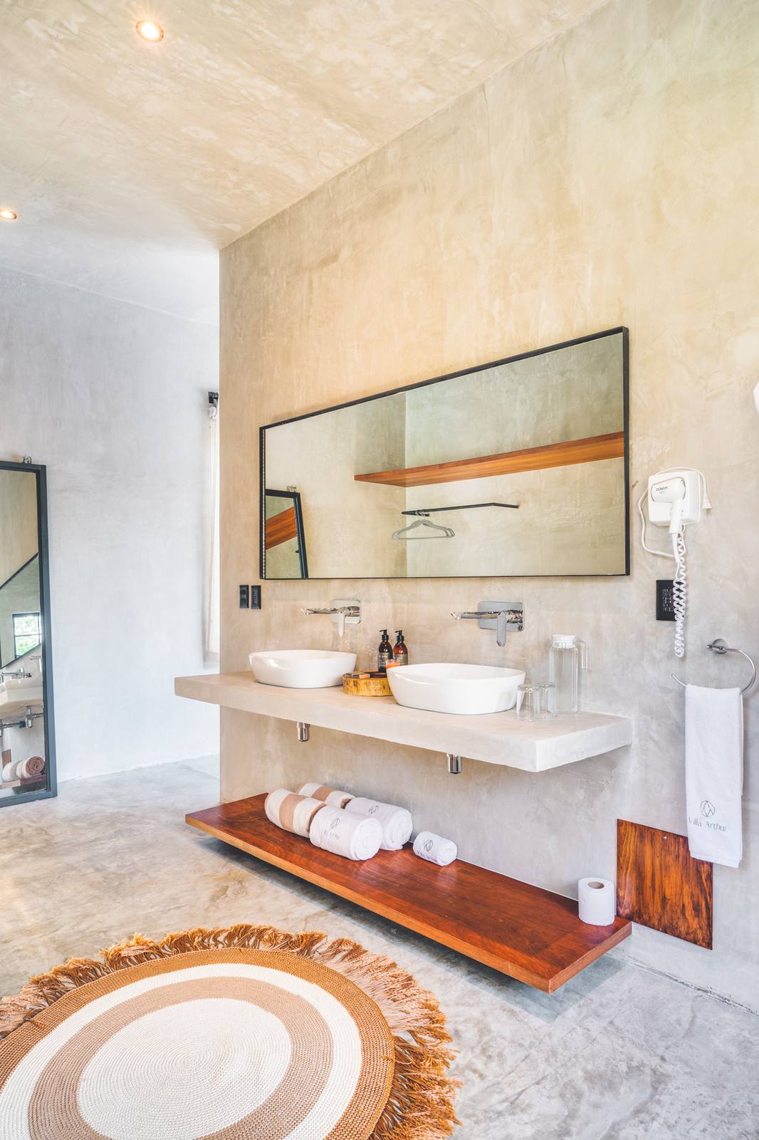 A bathroom with a floating wooden vanity