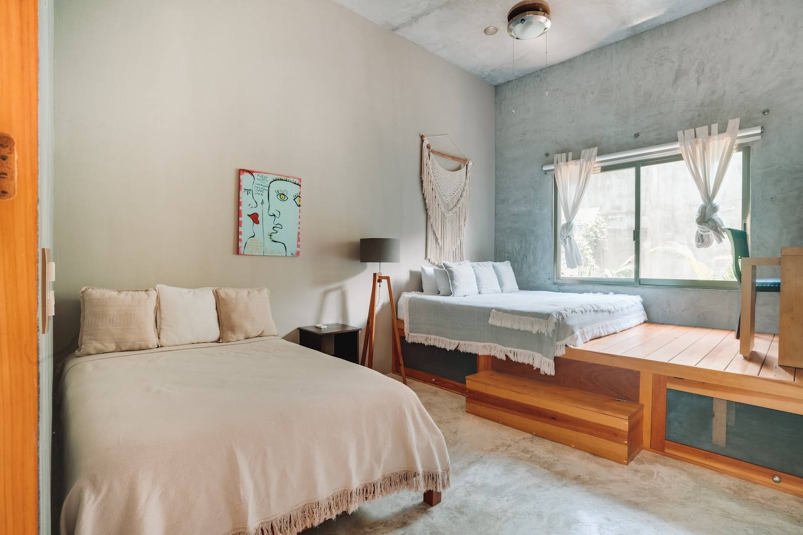 A bedroom with two beds and a raised platform
