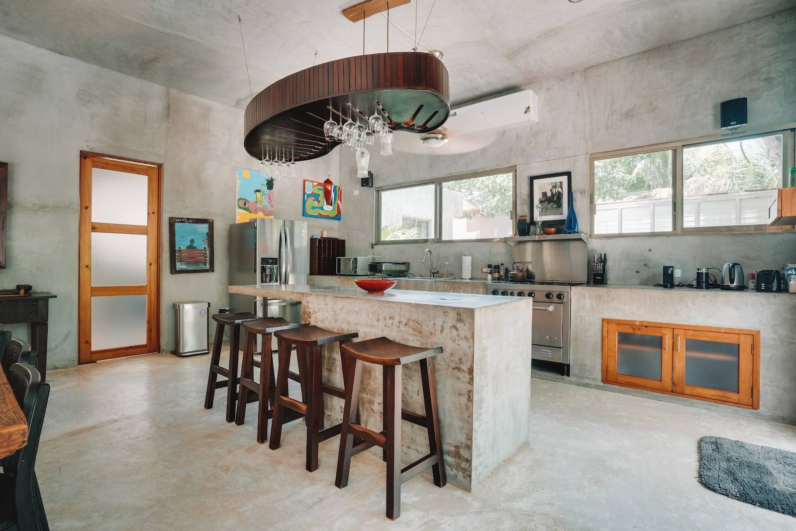The kitchen with a concrete island and bar stools