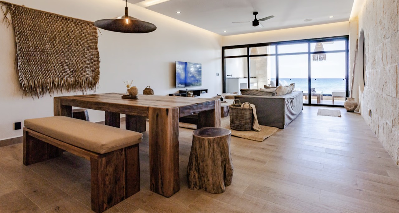 The dining table and living room, with the sea beyond the windows
