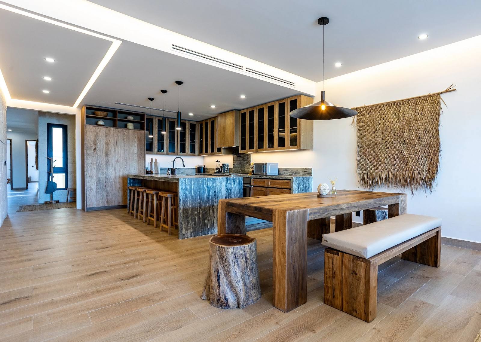 The dining table with benches and the kitchen behind